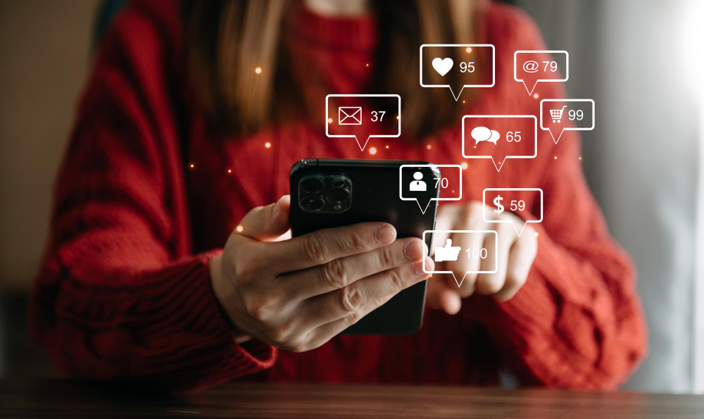 Jovem mexendo em suas redes sociais totalmente persuadida pelas estratégias de collab de suas marcas favoritas.